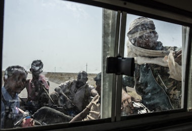 HAIZ, YEMEN - SEPTEMBER 19: Tahami Resistance fighters, a militia aligned with Yemen's Saudi-led coalition-backed government sit in the back of a truck on the way heading to the frontline of fighting on September 19, 2018 in Haiz, Yemen. A coalition military campaign has moved west along Yemen's coast toward Hodeidah, where increasingly bloody battles have killed hundreds since June, putting the country's fragile food supply at risk. (Photo by Andrew Renneisen/Getty Images)