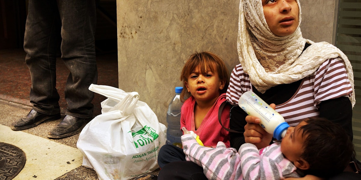 BEIRUT, LEBANON - NOVEMBER 16: Fatma, a Syrian woman from the city of Idlib, begs with her two children in a wealthy district of Beirut on November 16, 2013 in Beirut, Lebanon. As the war in neighboring Syria drags on for a third year, Lebanon, a country of only 4 million people, is now home to the largest number of Syrian refugees who have fled the conflict. The situation is beginning to put huge social and political strains on Lebanon as there is currently no end in sight to the war in Syria. According to the United Nations, almost two million Syrian refugees have been forced to flee their homes due to the ongoing war. Of those, around half are believed to be children. While there is no official data on the number of children and adults working on the streets Lebanon, it is estimated that it could be anywhere from 50,000 to 70,000. In wealthy districts of Beirut children and adults are viewed on nearly every block begging, looking through trash or offering pedestrians a shoe shine.  (Photo by Spencer Platt/Getty Images)