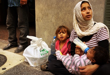 BEIRUT, LEBANON - NOVEMBER 16: Fatma, a Syrian woman from the city of Idlib, begs with her two children in a wealthy district of Beirut on November 16, 2013 in Beirut, Lebanon. As the war in neighboring Syria drags on for a third year, Lebanon, a country of only 4 million people, is now home to the largest number of Syrian refugees who have fled the conflict. The situation is beginning to put huge social and political strains on Lebanon as there is currently no end in sight to the war in Syria. According to the United Nations, almost two million Syrian refugees have been forced to flee their homes due to the ongoing war. Of those, around half are believed to be children. While there is no official data on the number of children and adults working on the streets Lebanon, it is estimated that it could be anywhere from 50,000 to 70,000. In wealthy districts of Beirut children and adults are viewed on nearly every block begging, looking through trash or offering pedestrians a shoe shine. (Photo by Spencer Platt/Getty Images)
