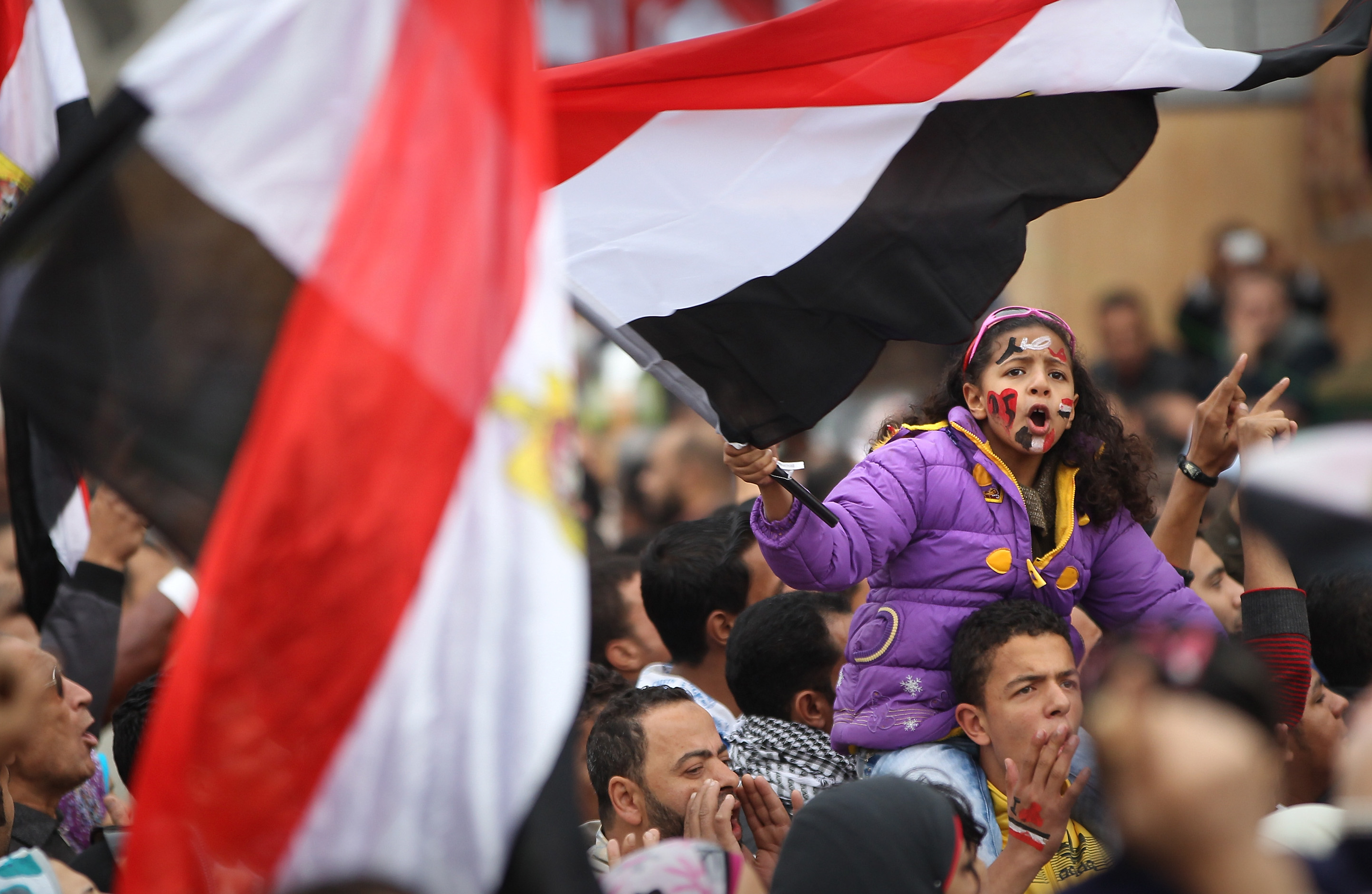 a woman holding a flag in the middle of a crowdf