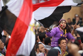 a woman holding a flag in the middle of a crowdf