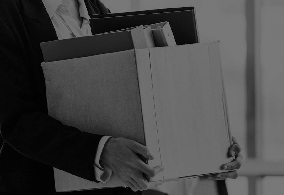 An resigning employee carrying a box of belongings