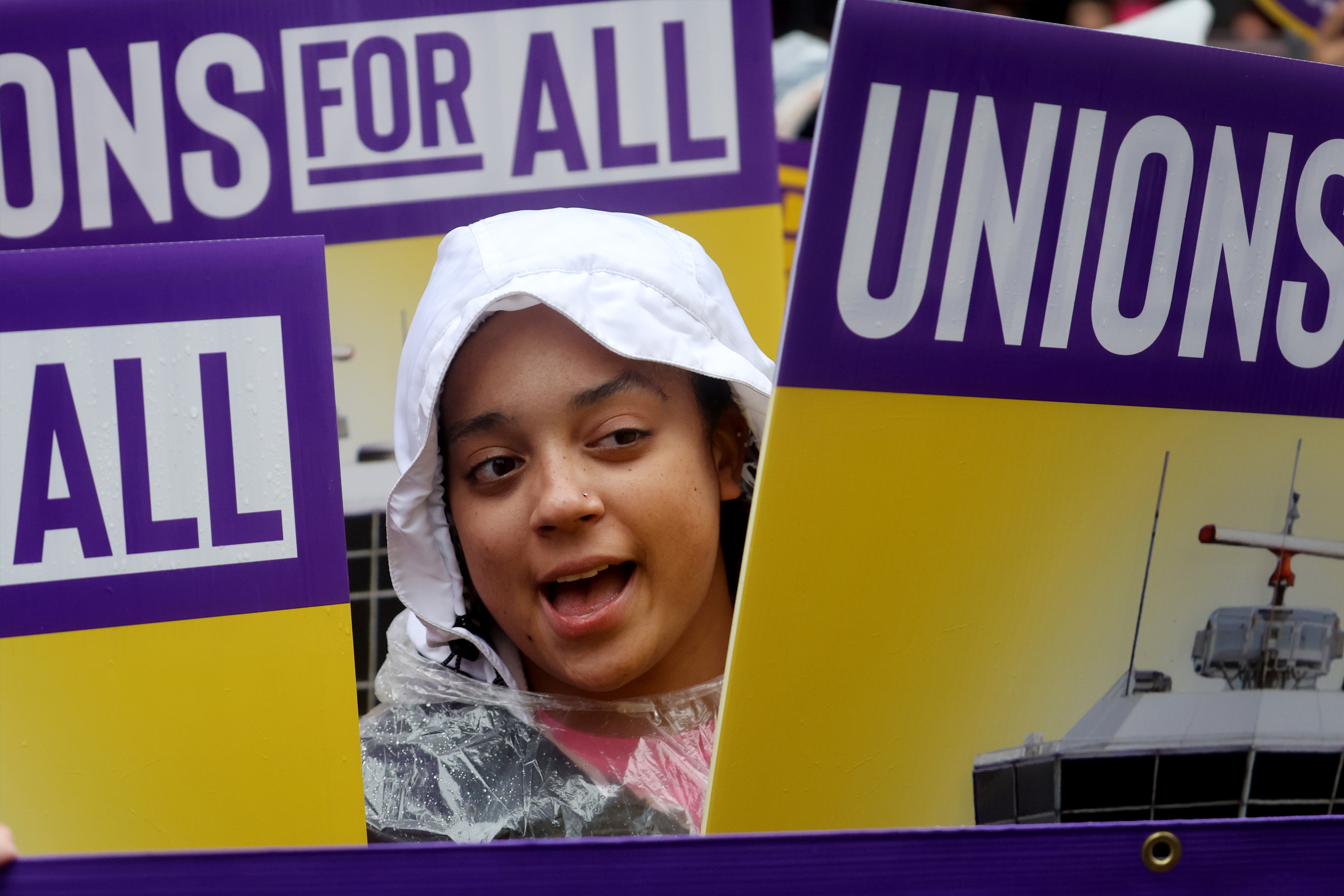 a young girl holding a sign with the words unions for all