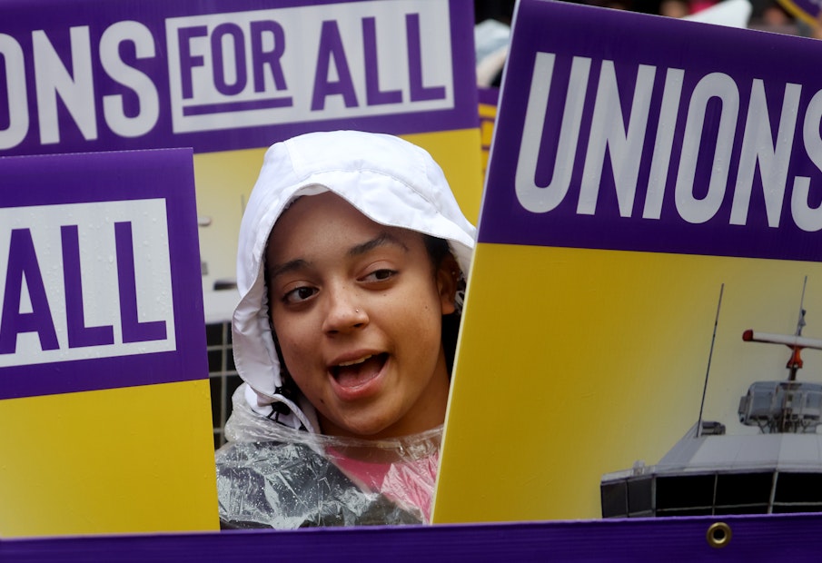 a young girl holding a sign with the words unions for all