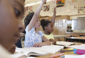 Children raising their hands in a classroom