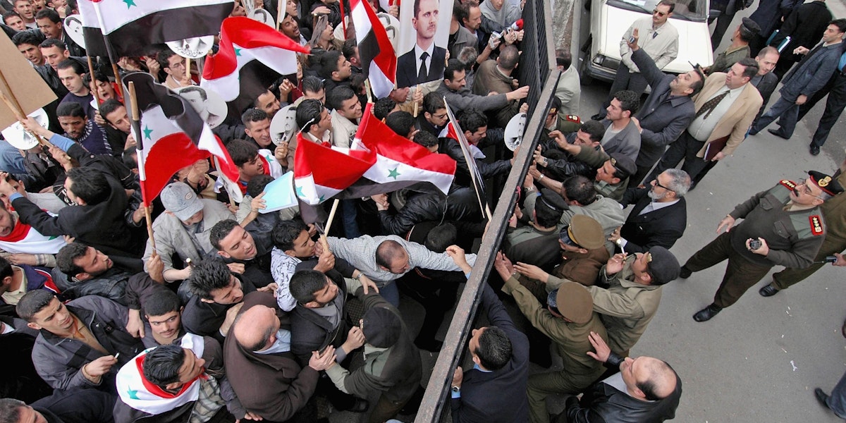 DAMASCUS, SYRIA - MARCH 10:  A pro-Assad demonstration quickly puts an end to a pro-democracy demonstration in front of the justice palace on March 10, 2005 in Damascus, Syria. The Lebanese Parliament emboldened by pro-Syrian demonstrations in Beirut voted to re-elect Lebanon's pro-Syrian Prime Minister, Omar Karami, who was forced stand down by pressure from opponents of Syria's occupation.  (Photo by Jeroen Kramer/Getty Images)