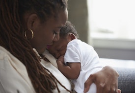 Black mother holding sleeping baby son