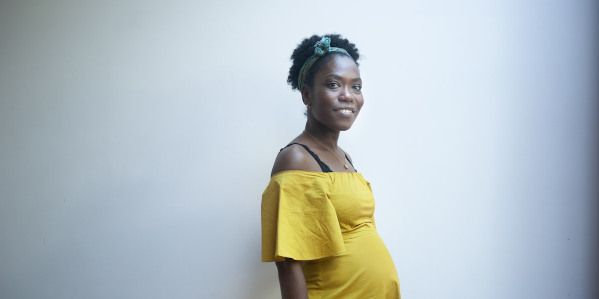 Indoors portrait of a beautiful pregnant woman, dressed in yellow.