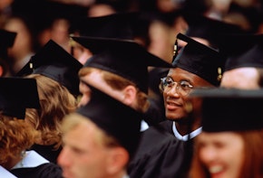 Graduates at graduation ceremony (focus on young man in glasses).