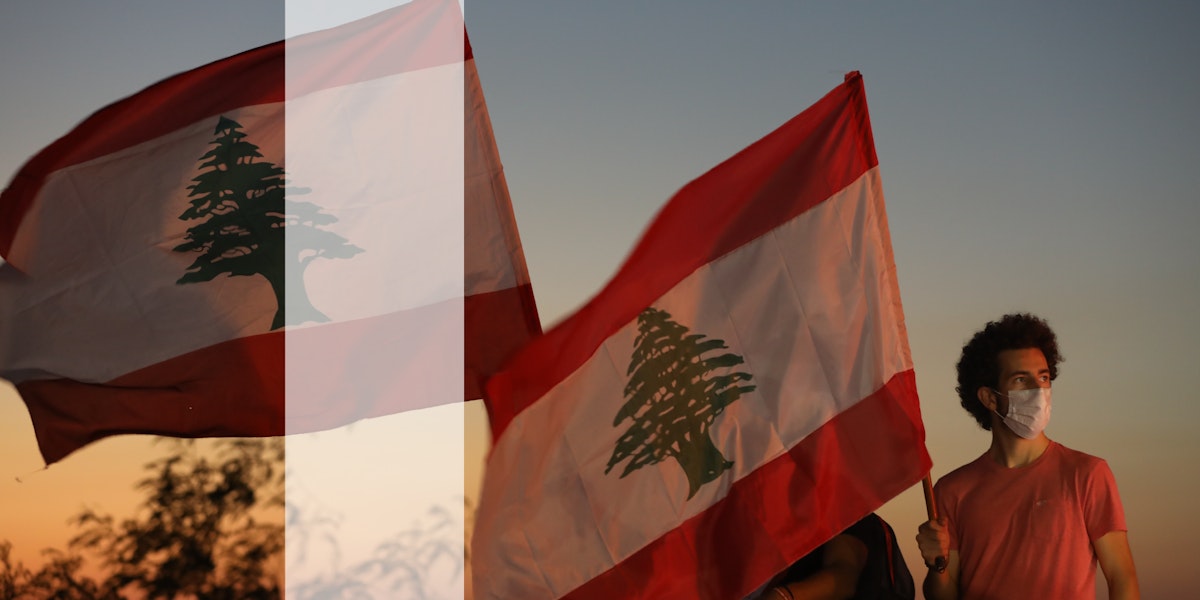 People wave Lebanese flags and chant to mark the one-year anniversary of anti-government protests on October 17, 2020 in Beirut, Lebanon.