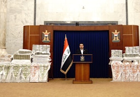 Iraqi prime minister Mohammed Shia al-Sudani stands in front of piles of money recovered from the “heist of the century.” Source: Twitter page of the Iraqi prime minister’s office, November 27, 2022,