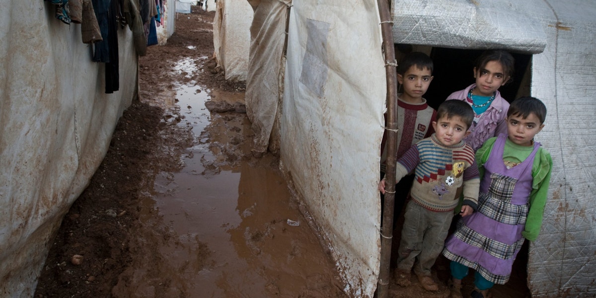 On 1 January, children stand in the entryway of their tent shelter, in the Bab Al Salame camp for internally displaced persons, near the border with Turkey, in Aleppo Governorate. A muddy and puddled walkway separates their tent from those of their neighbours. Laundry has been hung to dry nearby. Keeping clothing clean and dry has been a major challenge for residents. Residents have also expressed concern that hygiene conditions in the camp are worsening, increasing the risk of disease.

In early January 2014 in the Syrian Arab Republic, the ongoing conflict has affected some 9.3 million people. Of these, 6.5 million have been displaced internally. Syrians have also fled abroad, with more than 2.3 million people registered or awaiting registration with the United Nations High Commission for Refugees (UNHCR) in Egypt, Iraq, Jordan, Lebanon and Turkey. UNICEF support in the Syrian Arab Republic includes the distribution of clothing and other supplies to help keep children and their families healthy and warm during the winter; a polio vaccination campaign; the provision of primary health care services via both mobile medical teams and fixed centres; initiatives in water, sanitation and hygiene, including efforts to ensure continuous access to safe water in conflict-prone areas; the distribution of school supplies; and the provision of psychosocial support services for children and adolescents. United Nations agencies, including UNICEF, have appealed for US$6.5 billion to cover responses within the Syrian Arab Republic and host countries between January and December 2014. The appeal includes some US$2.3 billion for the 2014 Syrian Arab Republic Humanitarian Assistance Response Plan led by the Office for the Coordination of Humanitarian Affairs (OCHA) to aid people inside Syria and US$4.2 billion for the UNHCR-led Syria Regional Response Plan to aid refugees and host communities.