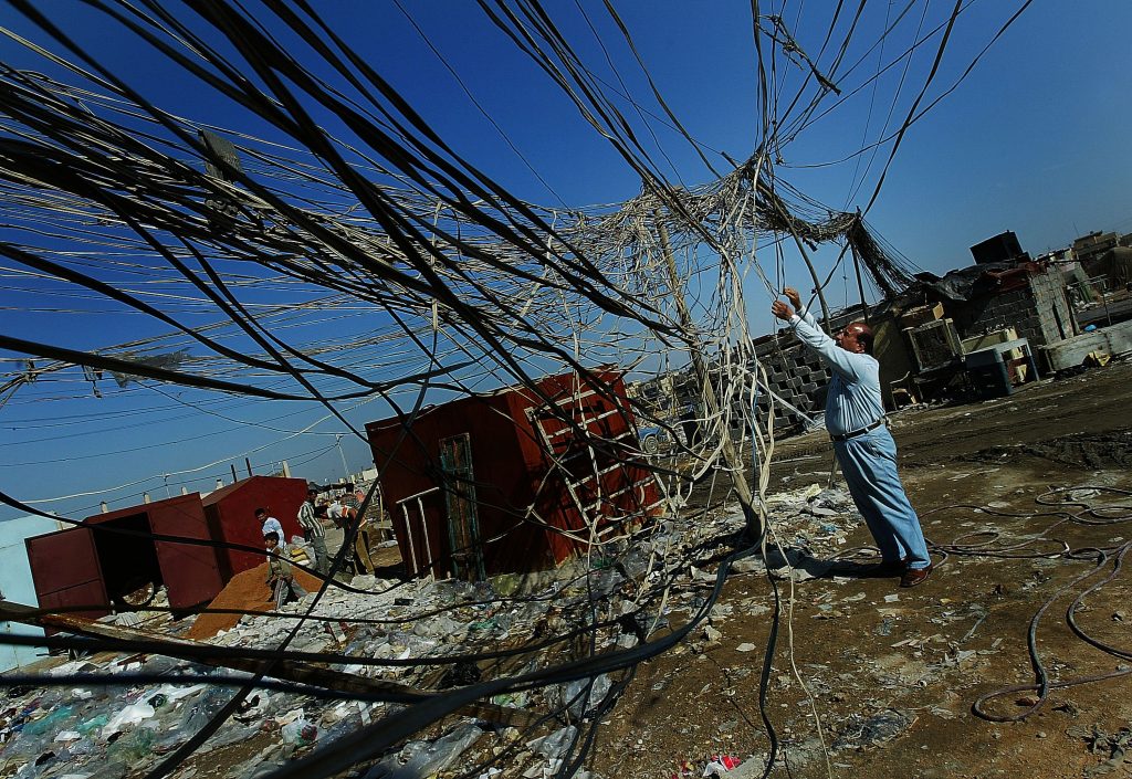 An Iraqi technician fixes the wires of a power generator on February 19, 2007, in the Sadr City neighborhood of Baghdad, Iraq.