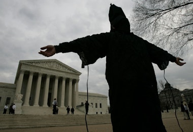 WASHINGTON - FEBRUARY 09:  Dressed as in infamous Abu Ghraib prison garb, Jose J. Rodriguez, protests the appointment of Alberto Gonzalez as the new U.S. Attorney General February 9, 2005 in Washington, DC. Members of D.A.W.N., the D.C. Anti-war Network, gathered outside the court to commit civil disobedience showing their opposition to Gonzalez and 