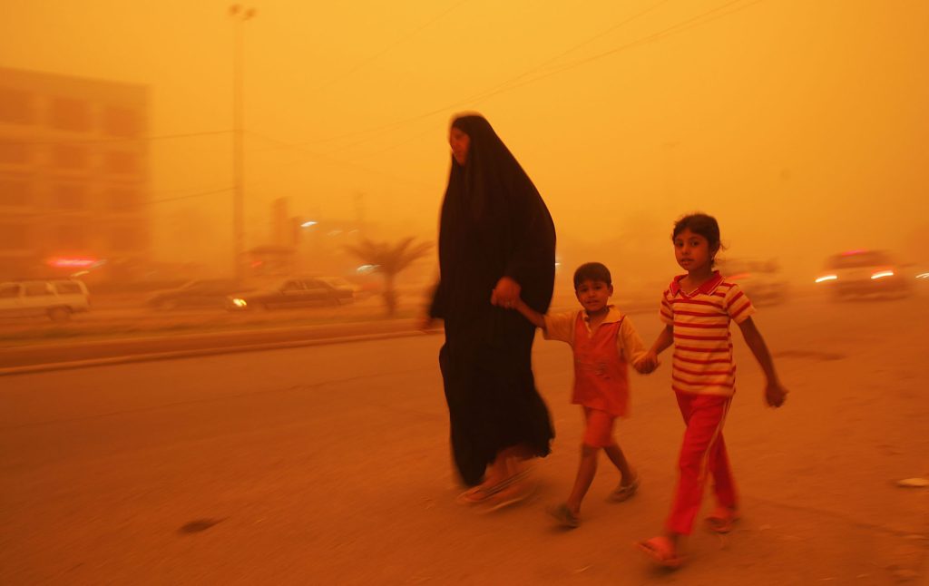 An Iraqi woman walks with her children during a sandstorm in April 2008 in Baghdad.