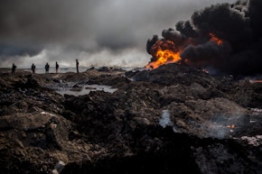 QAYYARAH, IRAQ - DECEMBER 23:  Fire crews work to extinguish a burning oil well on the outskirts of Qayyarah on December 23, 2016 in Qayyarah, Iraq. The fire crews, brought in from Kirkuk, have been working tirelessly with oil company representatives to extinguish the oil wells set ablaze by Daesh on their retreat from the city more than two months ago. The fire crews are currently working on their ninth oil well after extinguishing nearly all the wells close to the city.  (Photo by Chris McGrath/Getty Images)