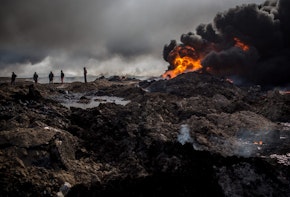 QAYYARAH, IRAQ - DECEMBER 23:  Fire crews work to extinguish a burning oil well on the outskirts of Qayyarah on December 23, 2016 in Qayyarah, Iraq. The fire crews, brought in from Kirkuk, have been working tirelessly with oil company representatives to extinguish the oil wells set ablaze by Daesh on their retreat from the city more than two months ago. The fire crews are currently working on their ninth oil well after extinguishing nearly all the wells close to the city.  (Photo by Chris McGrath/Getty Images)
