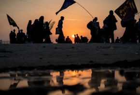 Silhouettes of crowded people walking at sunset time toward Karbala in Iraq for visiting the Holy Shrine of Imam Hussain