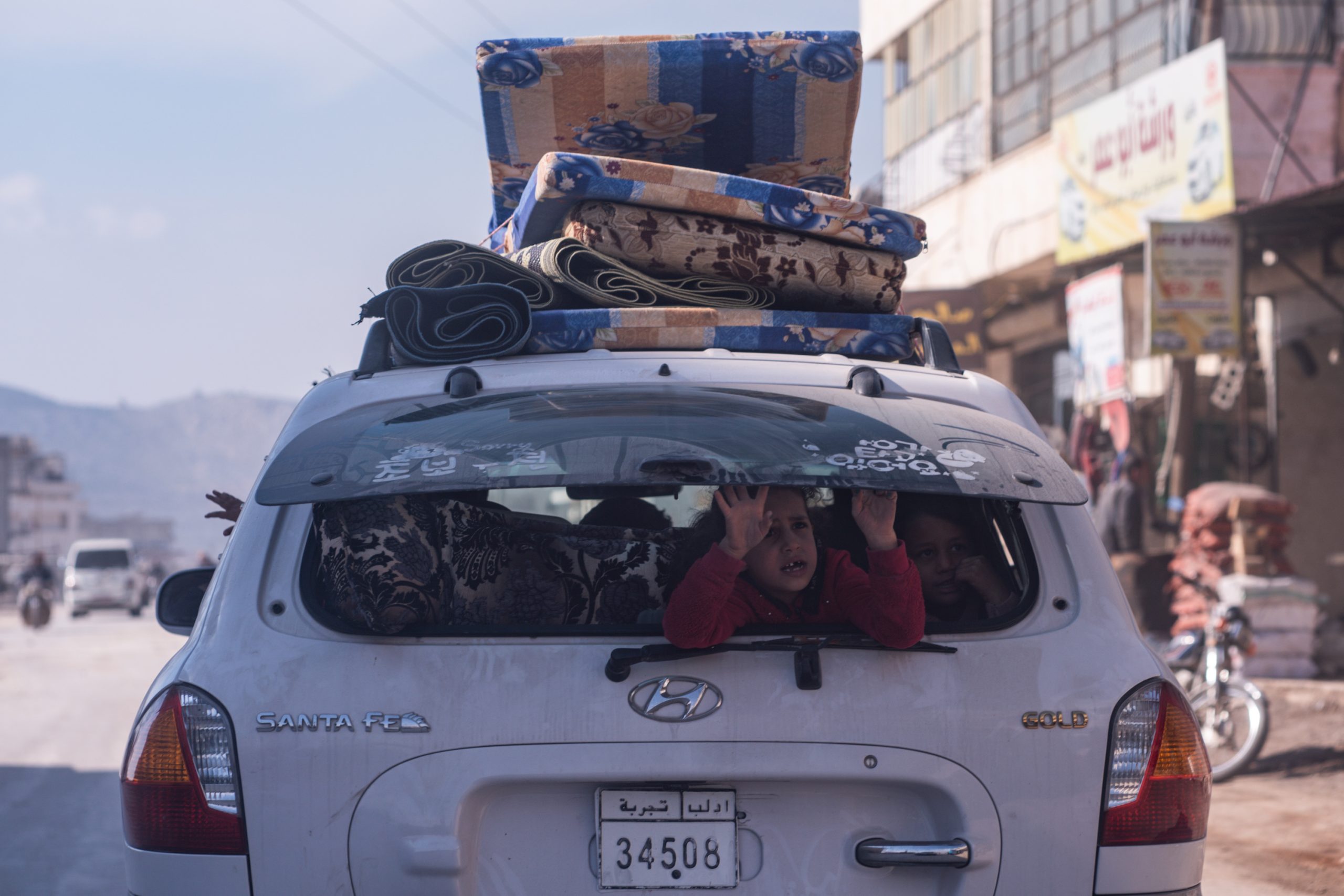 IDLIB, SYRIA - February 23 : A child sits in the back of the car while the family drive with their belongings, according to locals more than two million displaced because of war live in the northwest of Syria before the earthquake , on February 23, 2023 in Idlib, Syria. A 7.8-magnitude earthquake hit near Gaziantep, Turkey, in the early hours of February 6, followed by another 7.5-magnitude tremor just after midday. The quakes caused widespread destruction in southern Turkey and northern Syria and has killed more than 40,000 people. (Photo by Abdulmonam Eassa/Getty Images)