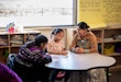 Young Female Indigenous Navajo Teacher Assisting Elementary Age Students in Class Room at an Elementary School in Monument Valley Utah