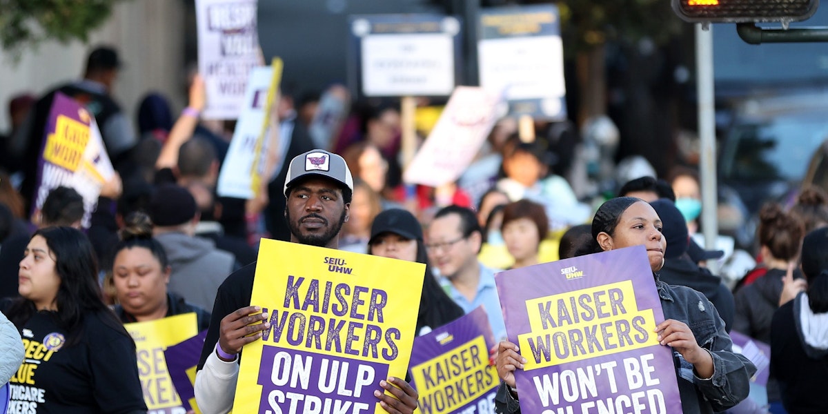 SAN FRANCISCO, CALIFORNIA - OCTOBER 04: Striking Kaiser Permanente workers hold signs as they march in front of the Kaiser Permanente San Francisco Medical Center on October 04, 2023 in San Francisco, California. More than 75,000 Kaiser Permanente workers went on strike Wednesday morning at hospitals and medical facilities in five states after labor negotiators could not reach an agreement to resolve a staffing level dispute. (Photo by Justin Sullivan/Getty Images)