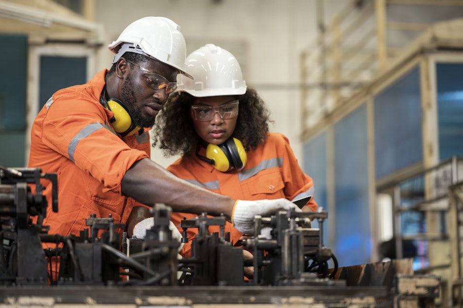 Process Safety for Every Operation in Welding Assembly of an Auto Parts Manufacturing Industry. Male and Female African American Engineers having a discussion about welding assembly process base on safety standard in a production line.