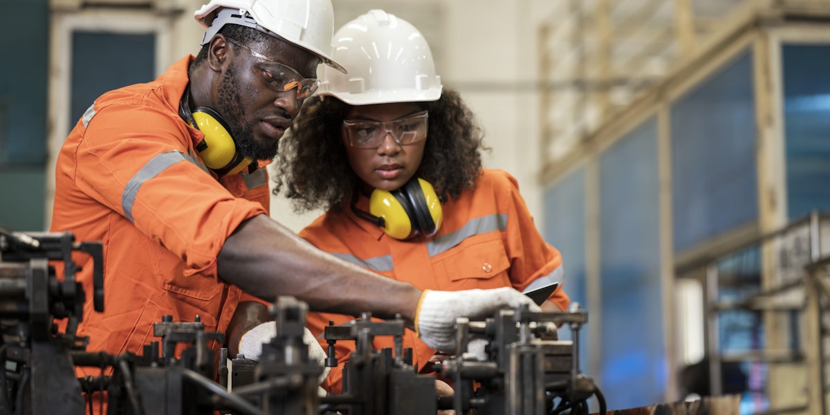 Process Safety for Every Operation in Welding Assembly of an Auto Parts Manufacturing Industry. Male and Female African American Engineers having a discussion about welding assembly process base on safety standard in a production line.