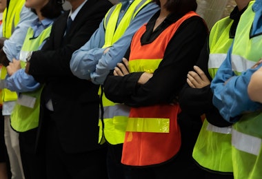 Large group of factory worker standing together in warehouse or storehouse . Logistics , supply chain and warehouse business concept .