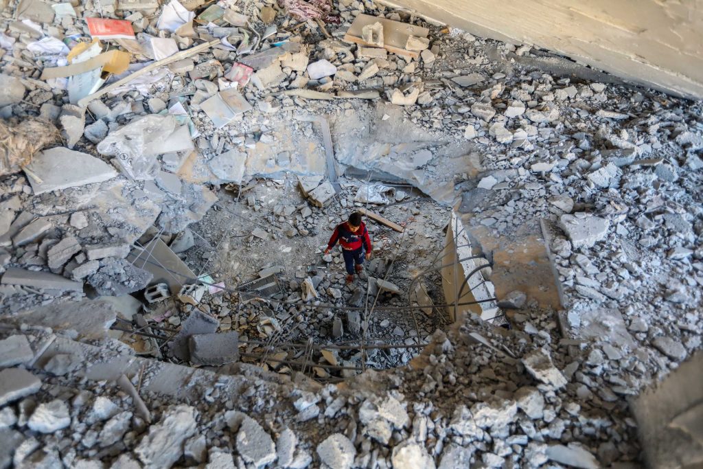 A young person inspects damage to a building following Israeli air strikes, on February 3 in Rafah, Gaza.