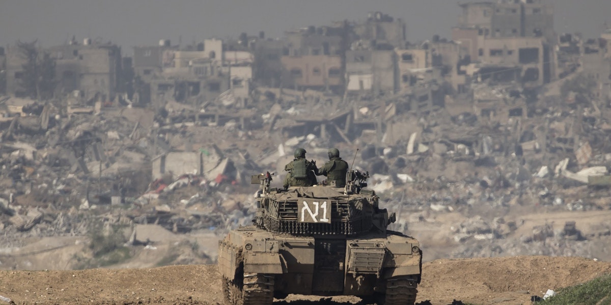 SOUTHERN ISRAEL, ISRAEL - JANUARY 19: Israeli soldiers stand on a tank as they secure the border with the Gaza Strip, as seen from a postion on the Israeli side of the border on January 19, 2024 in Southern Israel, Israel. Israel increased air raids in the south of the Gaza Strip, where medicines are expected for hostages held by Hamas and humanitarian aid for the Palestinian population. Despite Israel's recent troop drawdown in Gaza and the discussion of postwar plans by an Israeli cabinet minister, the country has continued its intensive bombardment of the Gaza Strip, particularly in the territory's south, as it seeks to destroy Hamas, the Palestinian militant group behind the Oct. 7 attacks. At least 1,200 civilians and soldiers have been killed in Israel since October 7 along with some 190 IDF soldiers killed fighting in Gaza ground operations, while more than 24,000 people have been killed in Gaza in the last three months, according to the territory's health ministry, and most of the population has been displaced. (Photo by Amir Levy/Getty Images)