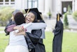 Excited college graduate hugs her mom after the graduation ceremony.