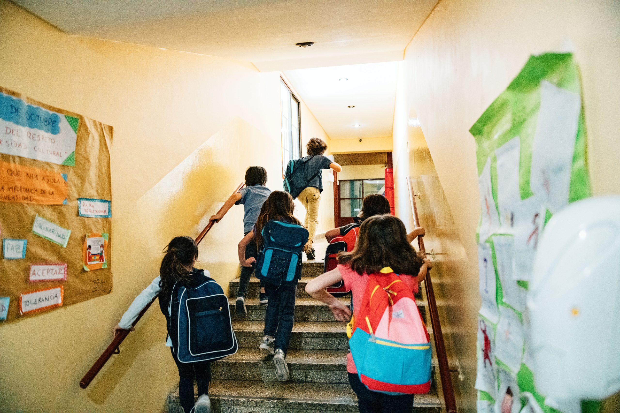 Rear view of a group of elementary age students going to class
