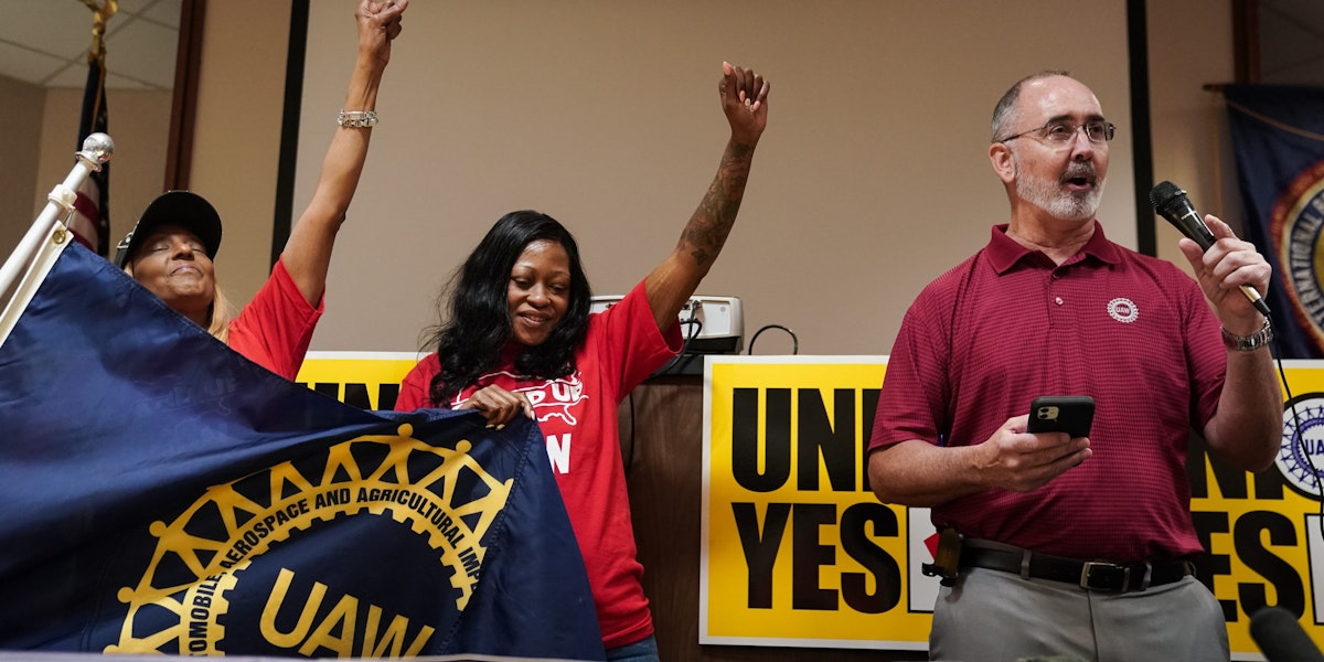 CHATTANOOGA, TENNESSEE - APRIL 19: United Auto Workers (UAW) President Shawn Fain, right, speaks as local organizers raise their fists at a UAW vote watch party on April 19, 2024 in Chattanooga, Tennessee. With over 51% of workers voting yes the UAW won the right to form a union at the plant. (Photo by Elijah Nouvelage/Getty Images)