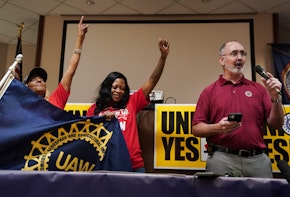 CHATTANOOGA, TENNESSEE - APRIL 19: United Auto Workers (UAW) President Shawn Fain, right, speaks as local organizers raise their fists at a UAW vote watch party on April 19, 2024 in Chattanooga, Tennessee. With over 51% of workers voting yes the UAW won the right to form a union at the plant. (Photo by Elijah Nouvelage/Getty Images)