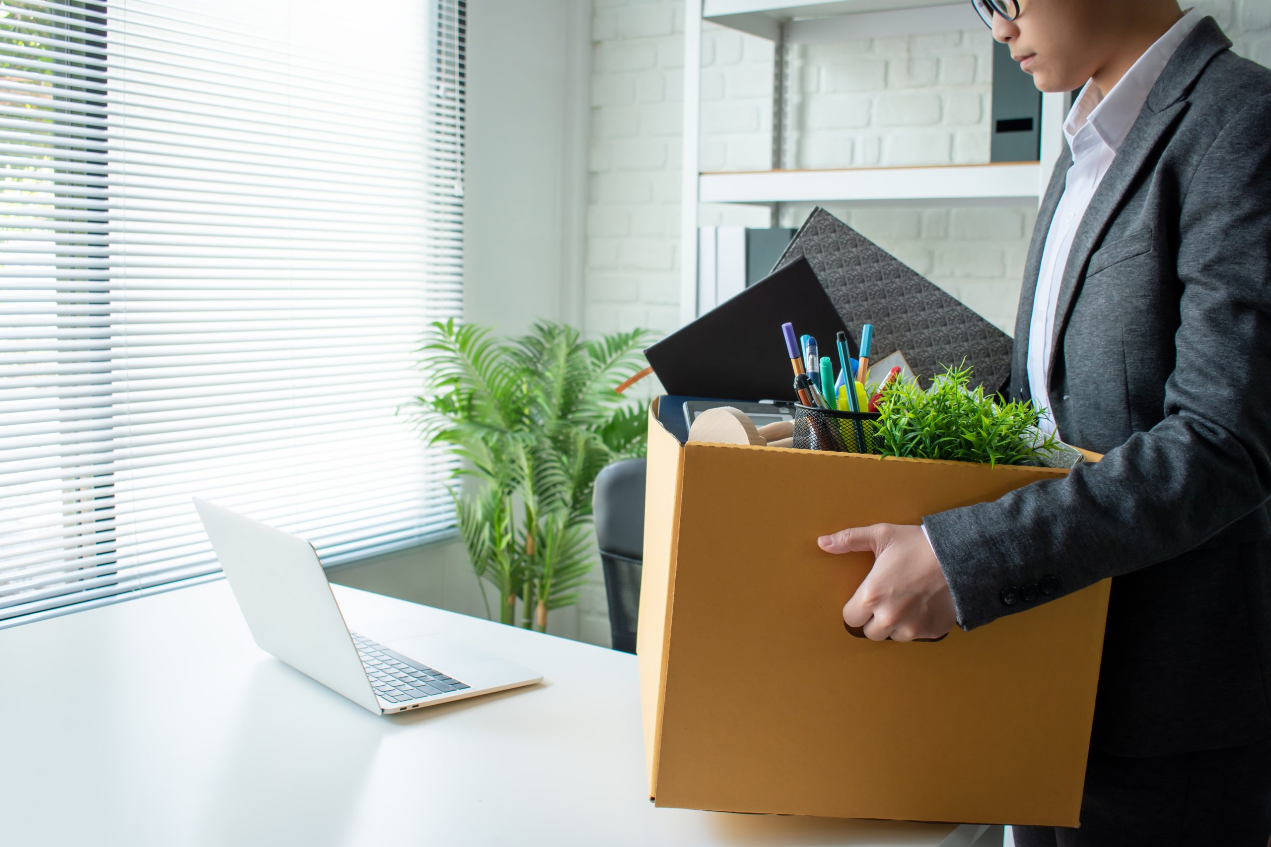 Young businessmen wear gray suits, feel stressed and are packing items into cardboard boxes. Unemployment and business concepts