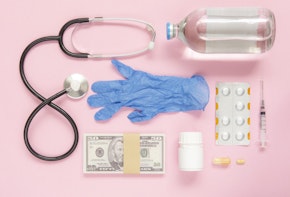 Medicine flat lay on pink color background with money