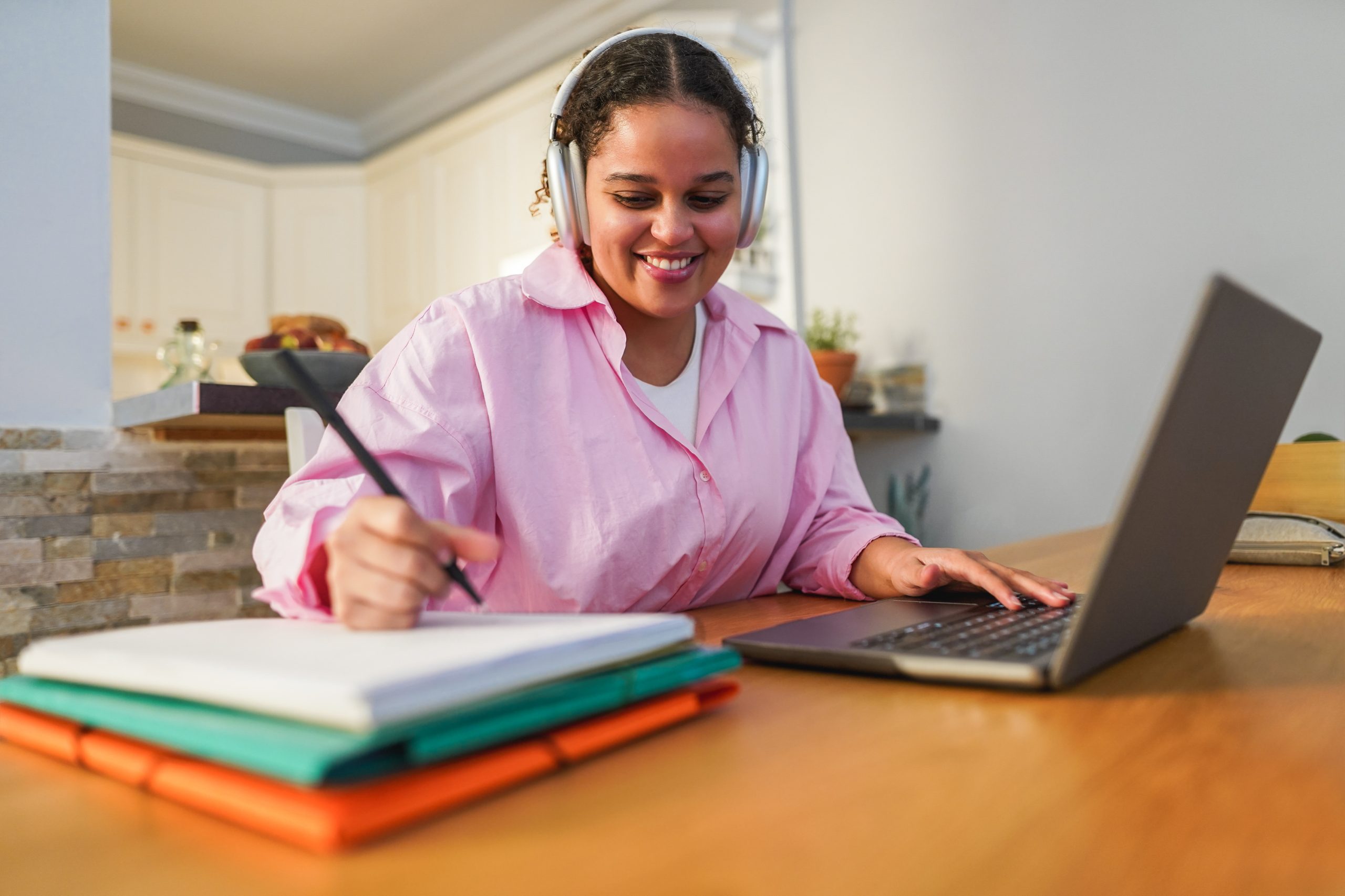 Girl using laptop computer from home while working on university project - Soft focus on face