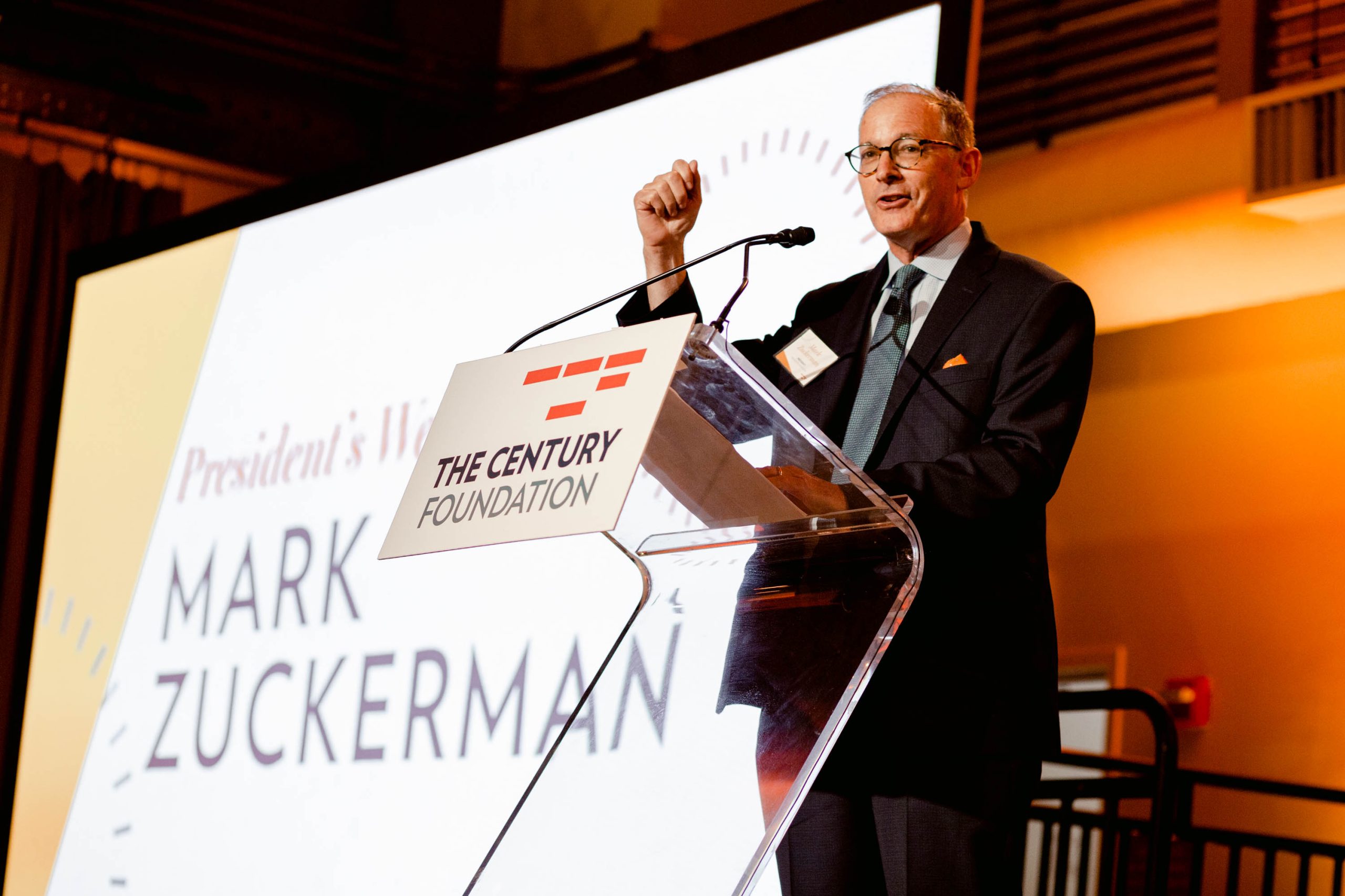 TCF President Mark Zuckerman stands at at a podium