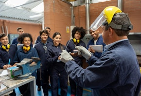 Group of college students in an engineering class looking at the teacher and paying attention - STEM education concepts