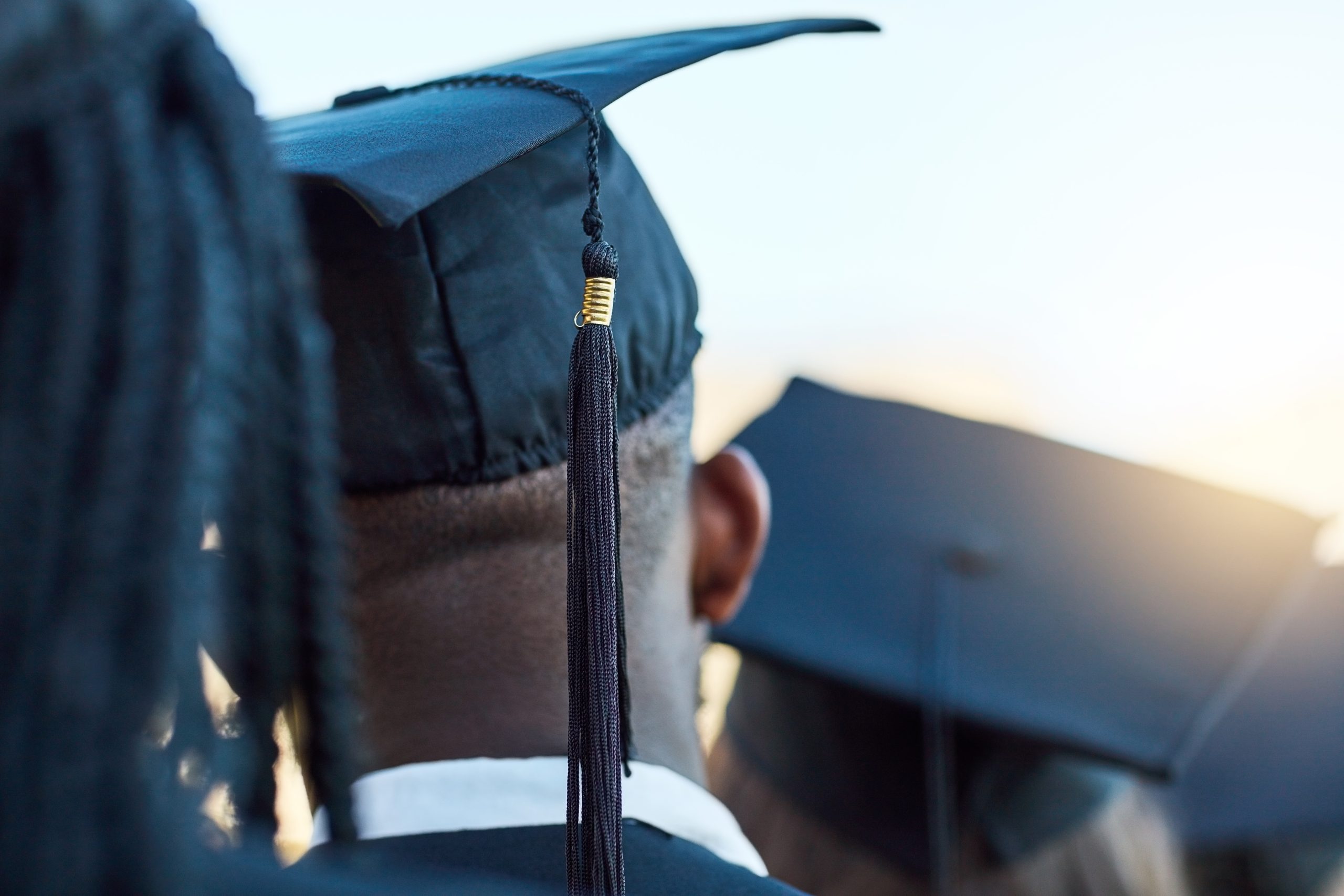 Rearview shot of a group of students standing in a line on graduation day