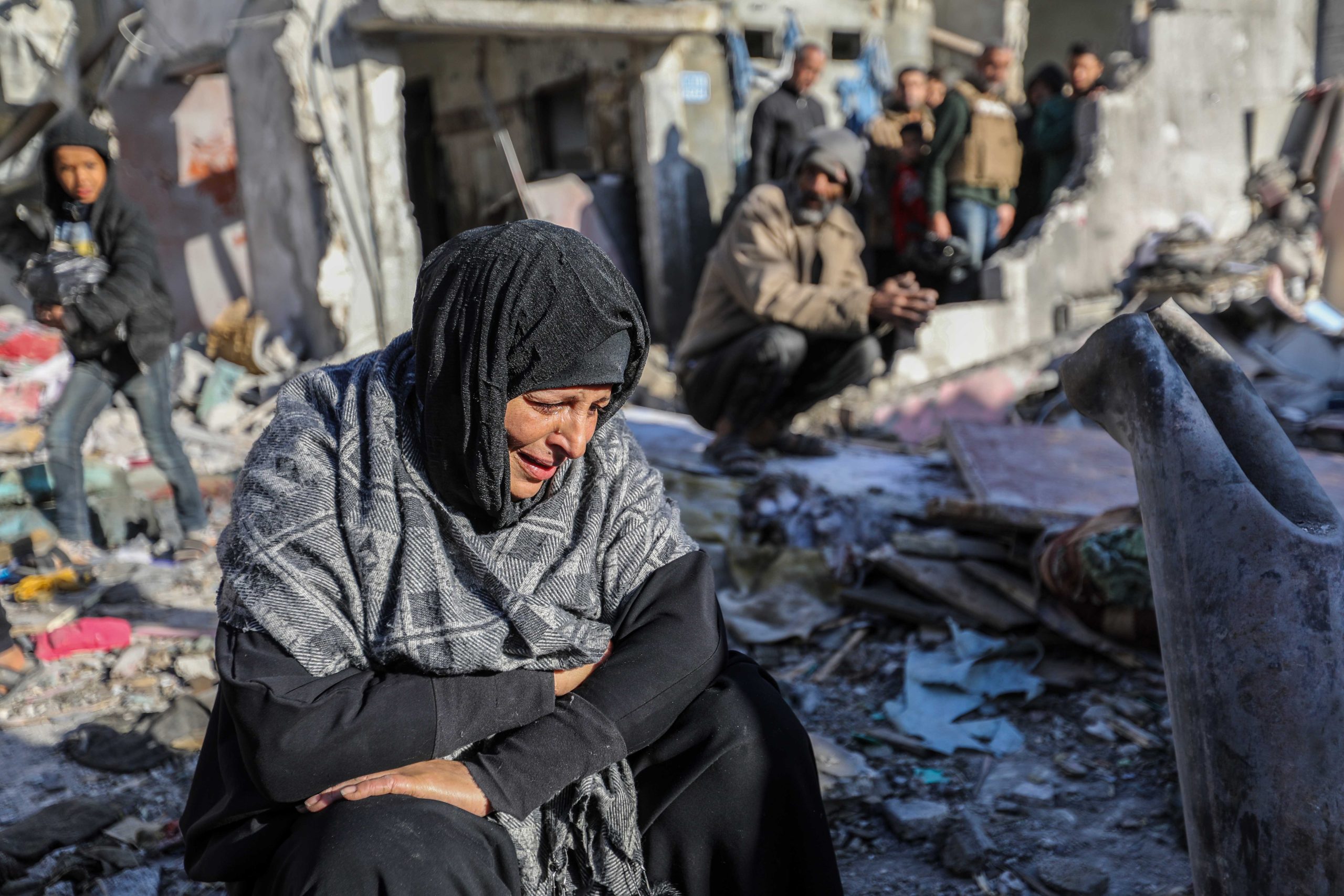  A woman sits amongst damaged homes caused by Israeli air strikes on January 18 in Rafah, Gaza. Source: Ahmad Hasaballah/Getty Images