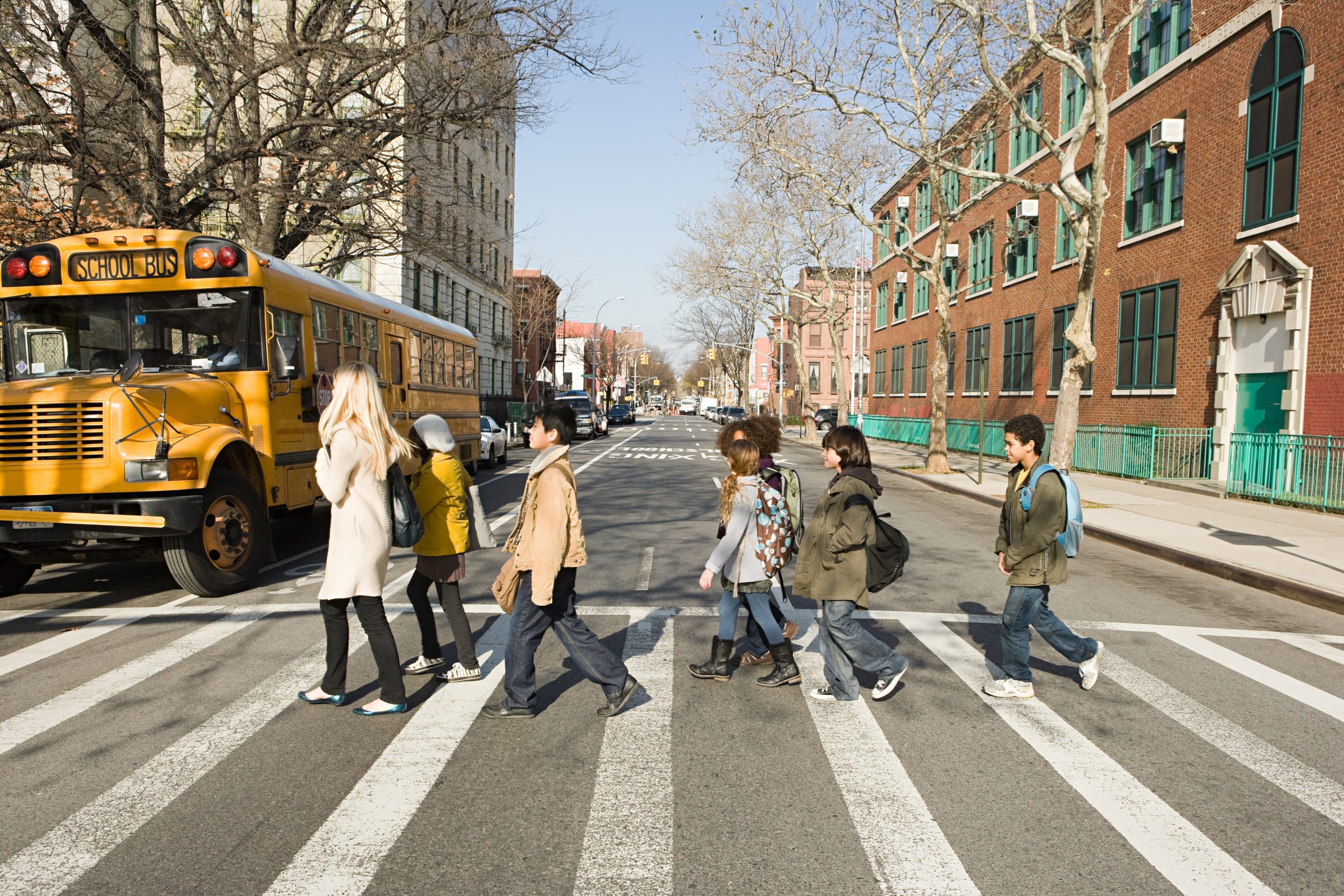 Teacher and pupils crossing road