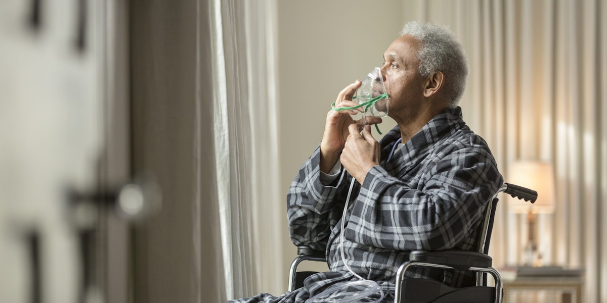 Senior African American man in wheelchair breathing with mask