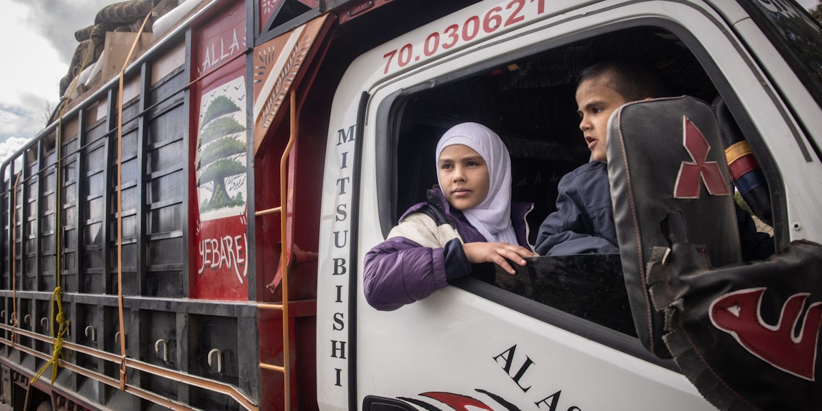 DAMASCUS, SYRIA - DECEMBER 21: 13-year-old Lana who was born in Syria and her brother 6-year-old Muhammad who was born in Lebanon wait in a truck carrying the family's possessions as their father Ahmed Muhammad Al-Nawa prepares papers to cross the border from Lebanon to Syria to return to his family’s home in the village of Harran for the first time in 10-years on December 21, 2024 in Damascus, Syria. 36-year-old Ahmed, was imprisoned and tortured by the regime for a year and half in the Mezzah Military Prison in 2012-2013, after his release, his wife and daughter were displaced from their home in the village of Harran, Eastern Ghouta, Damascus, during the Assad regime’s siege of the region in 2014. They fled to Lebanon where they have been living in a tent in the Hosh Al-Hareem camp for the past 10-years. Ahmed’s mother Umm Marwan stayed behind in Syria due to a heart condition that stopped her from travelling. While living in Lebanon, Ahmed and his wife had four more children that were born in Lebanon and have never meet their grandmother, other relatives or seen the family home. After the fall of the regime Ahmed decided to return home bringing all his possessions from Lebanon and giving his mother the chance to meet her grandchildren face to face for the first time. (Photo by Chris McGrath/Getty Images)