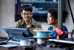 Build a Software Development Team to Running Your Business Growth.  Software Engineers on the project discuss a database design workflow and technical issues in a tech business office.