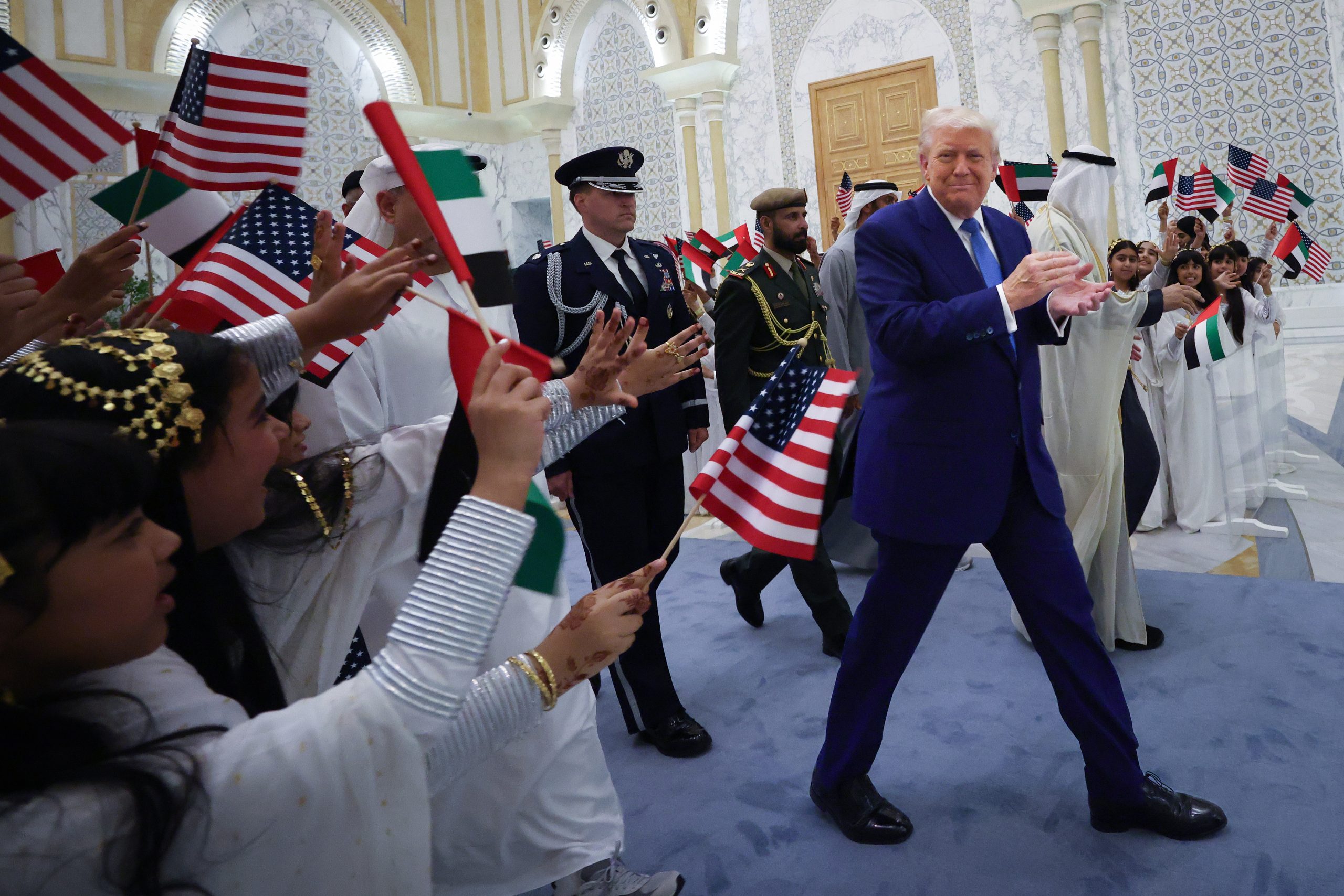 ABU DHABI, UNITED ARAB EMIRATES  - MAY 15: U.S. President Donald J. Trump is greeted by young girls as he arrives for an official arrival ceremony at Qasr al Watan (Palace of the Nation) May 15, 2025, in Abu Dhabi, United Arab Emirates. Trump is on the third day of his visit to the Gulf to underscore the strategic partnership between the United States and regional allies including the UAE, focusing on security and economic collaboration. (Photo by Win McNamee/Getty Images)