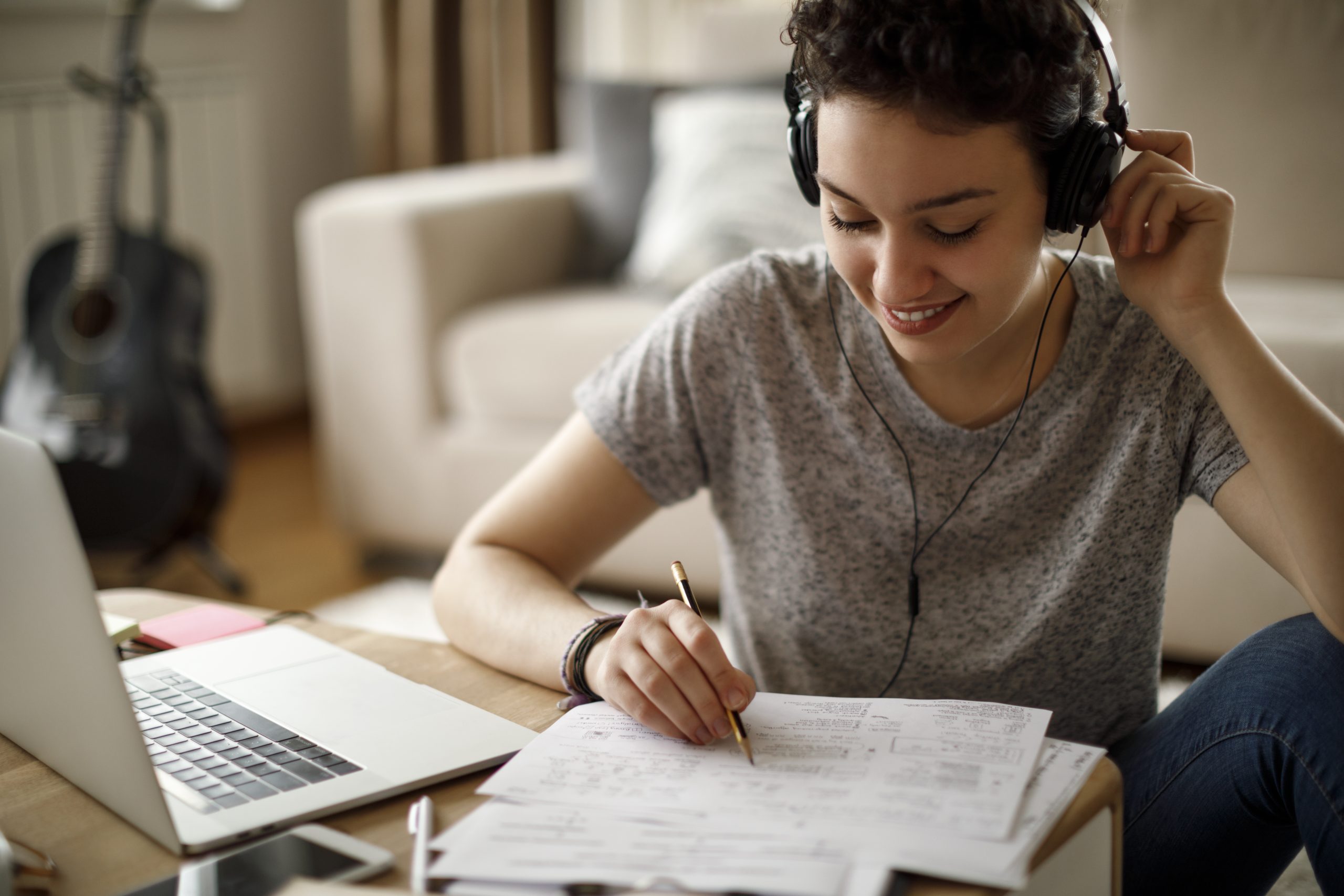 Female student studying and listening to music at home
