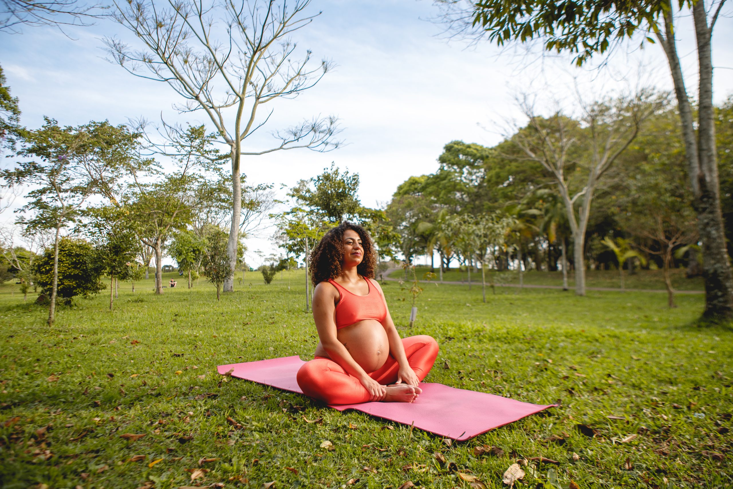 Brazilian, black and pregnant woman doing yoga outdoors on a sunny day
