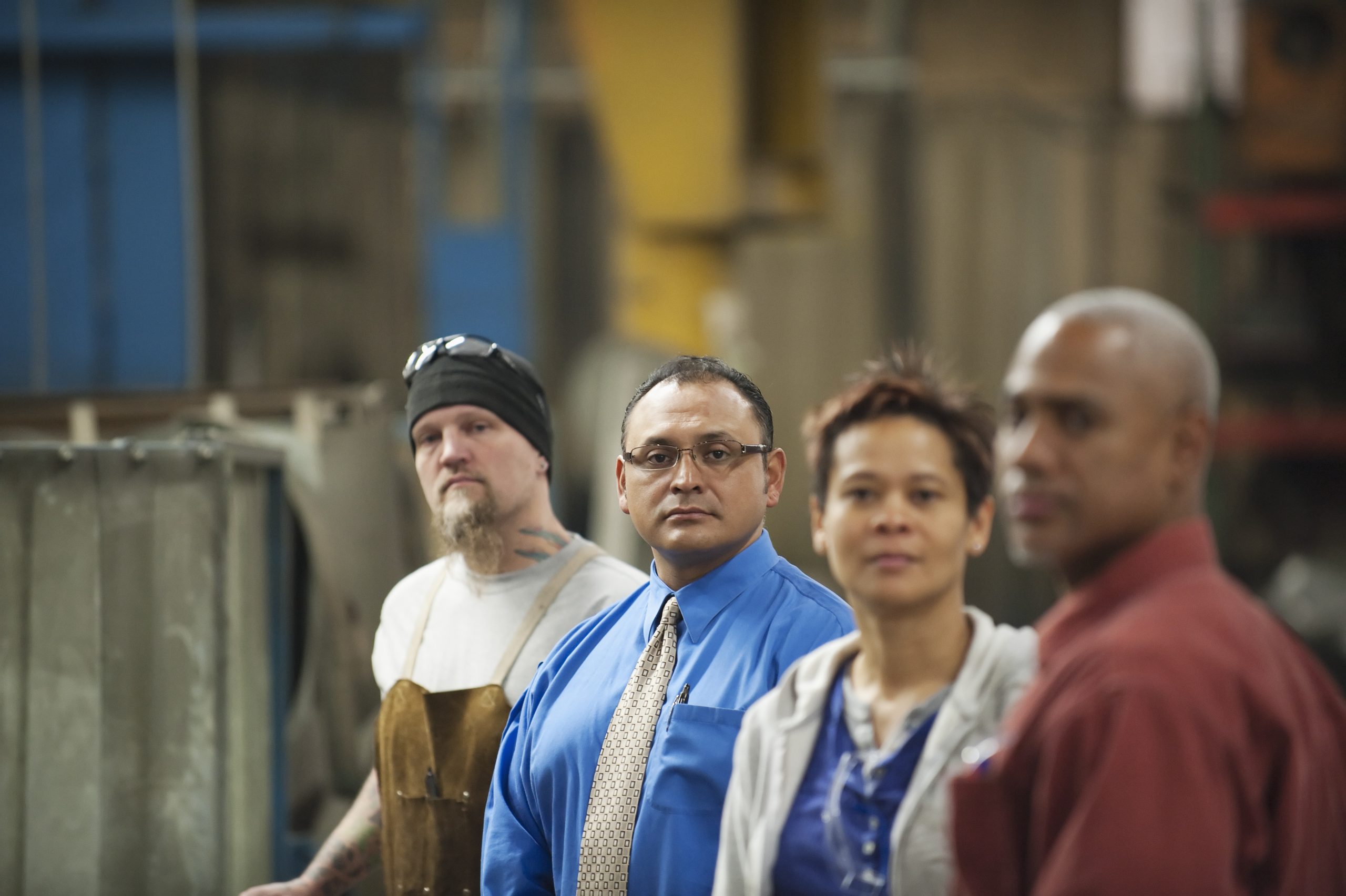 Manager and workers standing in factory