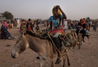 ADRE, CHAD - APRIL 24: Newly arrived refugee from Darfur in Sudan, sit on donkey as they head to their shelters on April 24, 2024 in Adre, Chad. Since the beginning of the recent conflict between the paramilitary Rapid Support Forces (RSF) and the the Sudanese Armed Forces, (SAF), which began in March 2023, over 600,000 new refugees have crossed the border from Darfur in Sudan, into Chad. The total number of refugees, including those from previous conflicts, now stands at 1.2 million. Aid agencies, including The World Food Programme, (WFP), Médecins Sans Frontières (MSF) and the United Nations High Commissioner for Refugees, (UNHCR), already struggling with acute supply shortages, have warned that the life-saving programmes in Chad, will ‘grind to a halt in a matter of weeks without urgent funding’. Chad is now home to one of the largest and fastest-growing refugee populations in Africa. (Photo by Dan Kitwood/Getty Images)